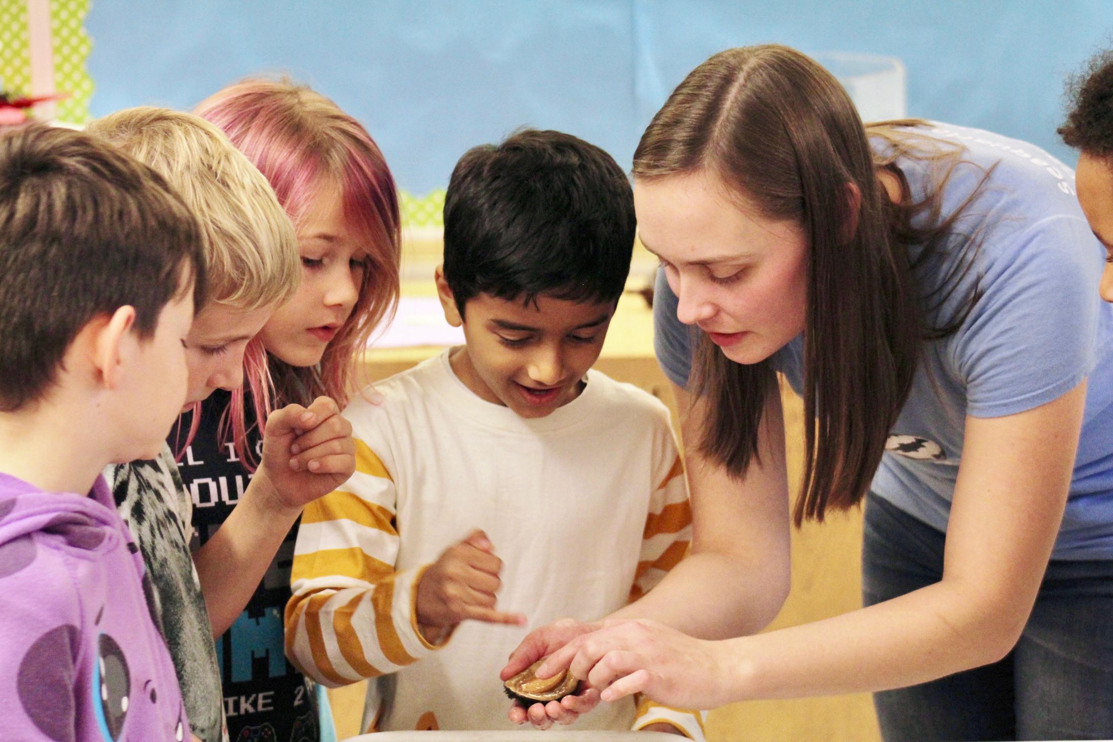 Researchers teaching with small children about marine life